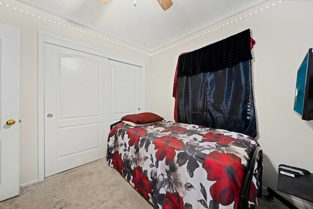 bedroom featuring a textured ceiling, carpet floors, a closet, and ceiling fan