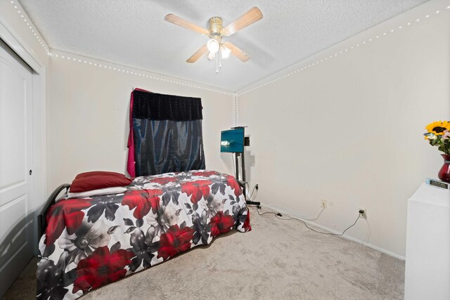 carpeted bedroom featuring ceiling fan, a closet, and a textured ceiling