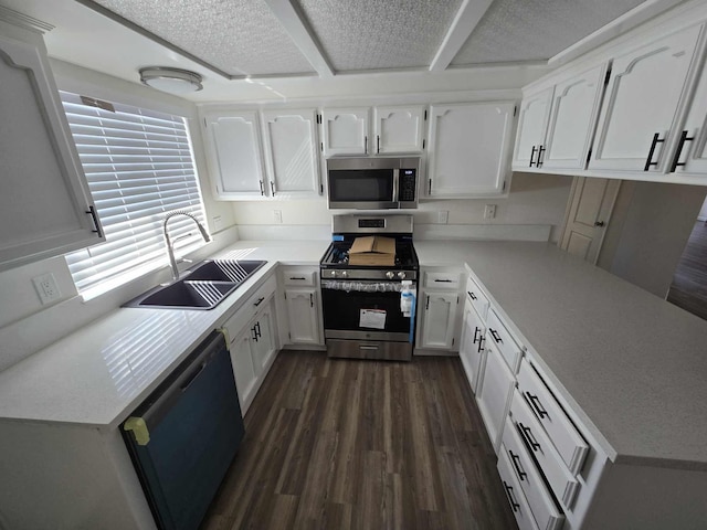 kitchen featuring a sink, stainless steel appliances, dark wood-type flooring, white cabinets, and light countertops