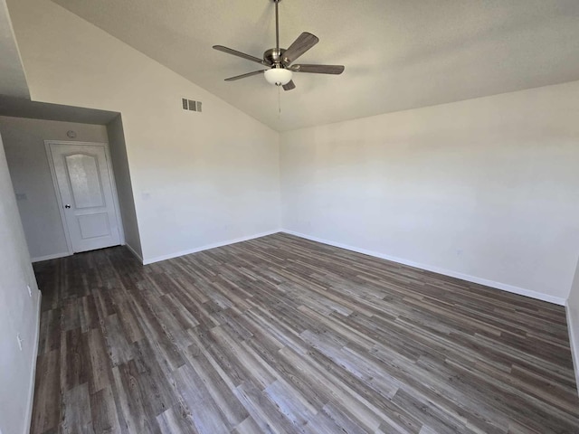 spare room with visible vents, baseboards, dark wood finished floors, vaulted ceiling, and a ceiling fan