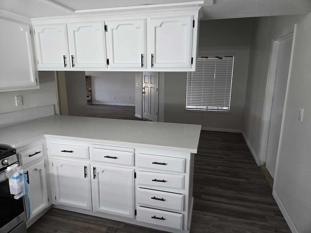 kitchen featuring stainless steel range with electric stovetop, a peninsula, light countertops, and white cabinetry