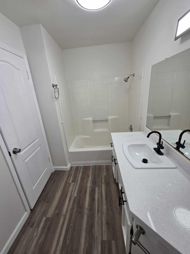 full bathroom with baseboards, bathing tub / shower combination, wood finished floors, and vanity