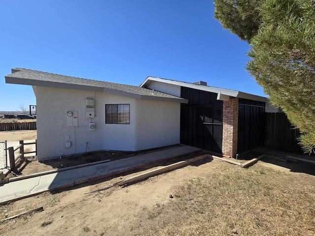 view of home's exterior with fence and stucco siding