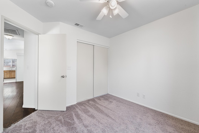 unfurnished bedroom featuring carpet floors, baseboards, visible vents, and a closet