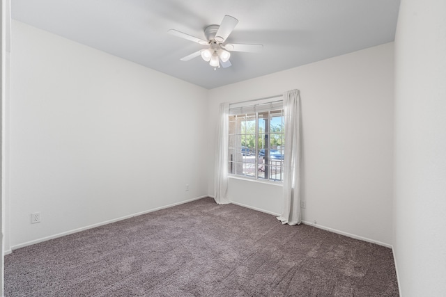 spare room featuring carpet floors, a ceiling fan, and baseboards