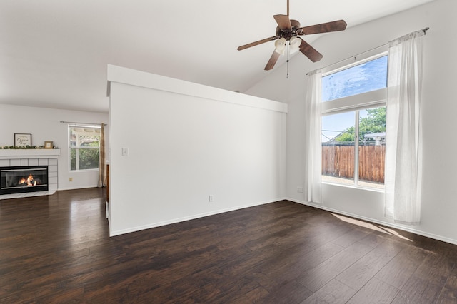 empty room featuring dark wood-style flooring, a fireplace, high vaulted ceiling, a ceiling fan, and baseboards
