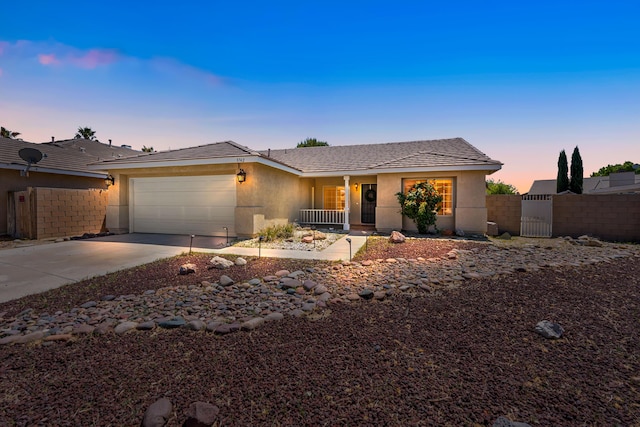 ranch-style house featuring fence, a garage, stucco siding, a gate, and driveway