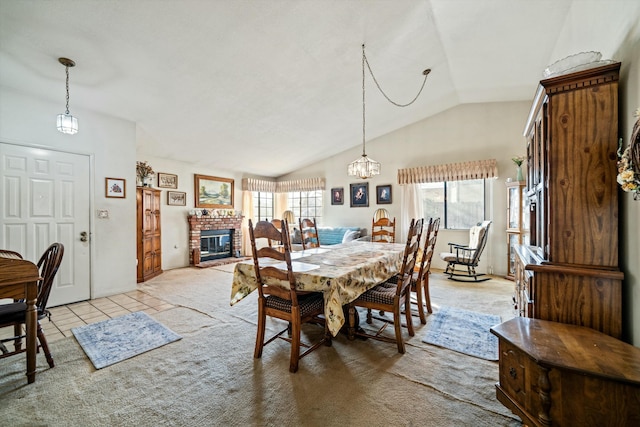 dining room featuring a wealth of natural light, light carpet, vaulted ceiling, and a fireplace