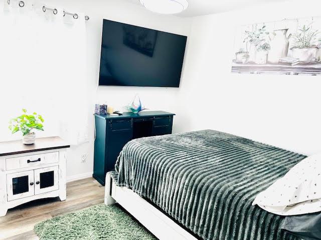 bedroom with baseboards and wood finished floors