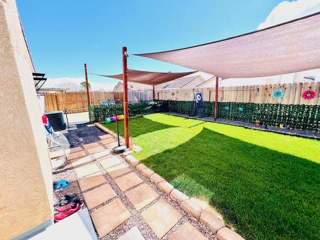 view of yard featuring central air condition unit, a patio, and a fenced backyard