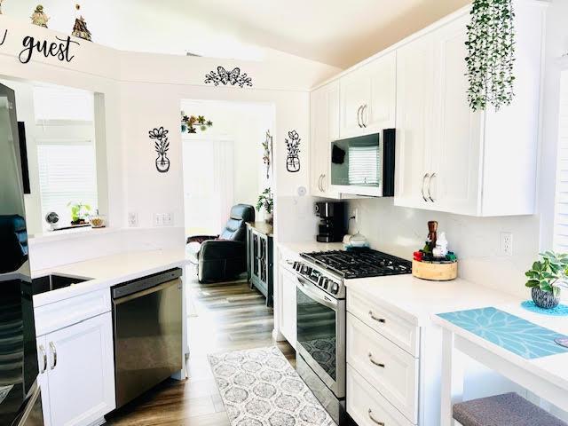 kitchen featuring appliances with stainless steel finishes, white cabinetry, and light countertops