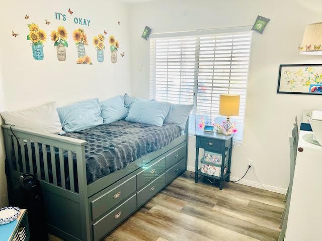 bedroom with baseboards and wood finished floors