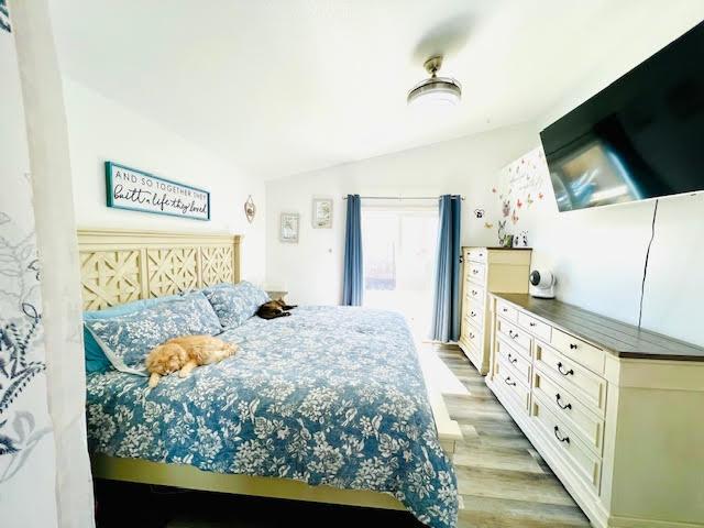 bedroom featuring vaulted ceiling and light wood-style flooring