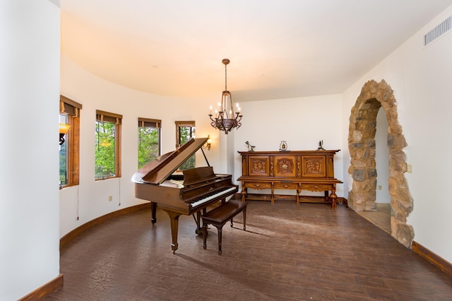 living area featuring baseboards, wood finished floors, visible vents, and a notable chandelier