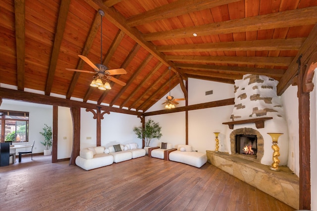 unfurnished living room featuring hardwood / wood-style floors, a warm lit fireplace, vaulted ceiling with beams, wood ceiling, and ceiling fan