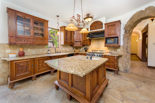 kitchen featuring stone tile flooring, extractor fan, brown cabinets, and black appliances