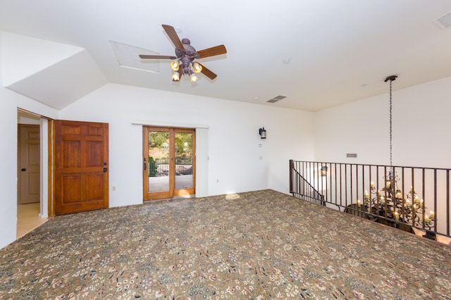 empty room with lofted ceiling, a ceiling fan, and visible vents