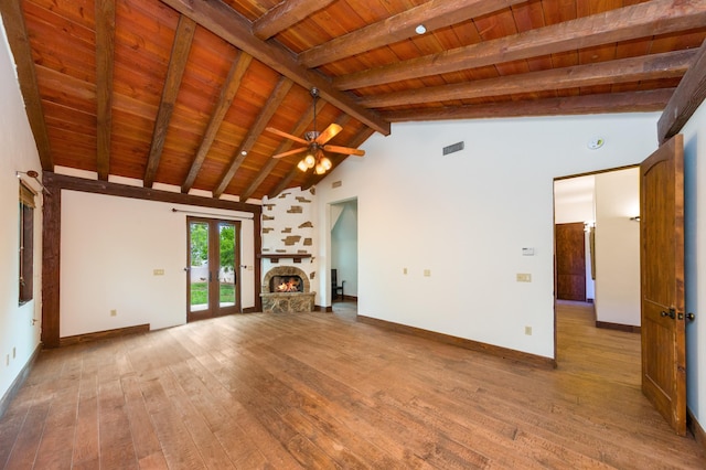 unfurnished living room featuring beam ceiling, baseboards, ceiling fan, wood ceiling, and wood-type flooring