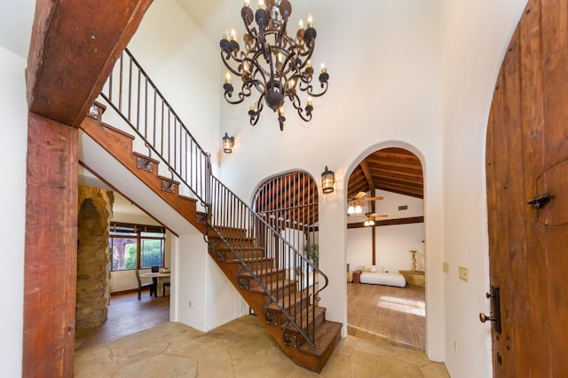 entryway featuring arched walkways, a notable chandelier, and stairway