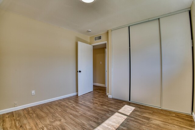 45209 Lorimer Ave, Lancaster, CA 93534 - unfurnished bedroom with light wood finished floors, baseboards, and a closet