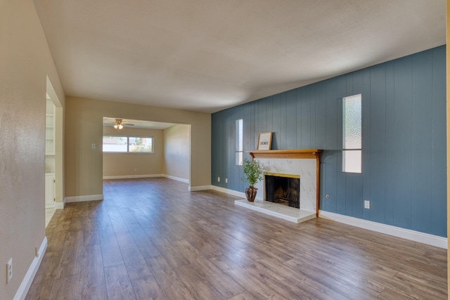 45209 Lorimer Ave, Lancaster, CA 93534 - unfurnished living room featuring a premium fireplace, wood finished floors, a ceiling fan, and baseboards