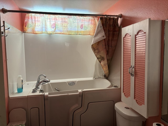 bathroom featuring toilet and a bathtub