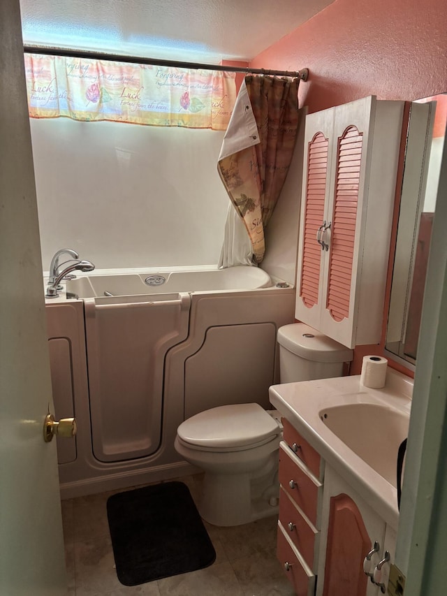 bathroom featuring vanity, tile patterned floors, and toilet