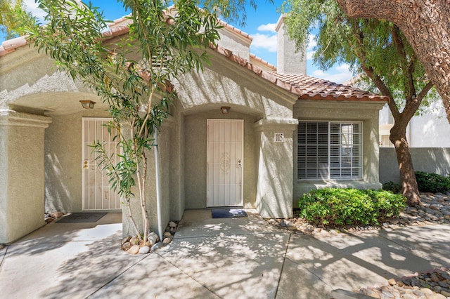 37940 E 42nd St Apt 115, Palmdale, CA 93552 - property entrance with a tile roof, stucco siding, and a chimney