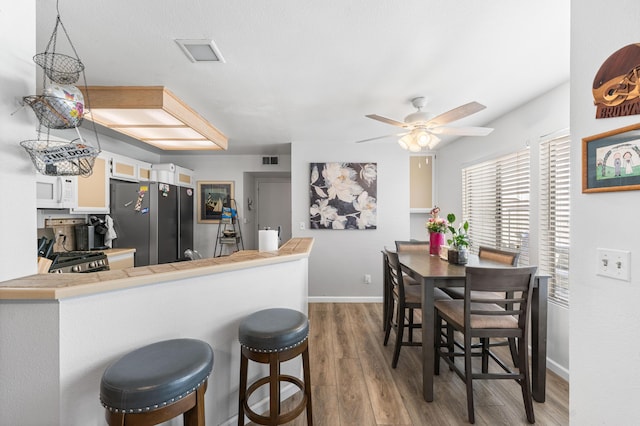 37940 E 42nd St Apt 115, Palmdale, CA 93552 - kitchen featuring freestanding refrigerator, stove, white microwave, light wood-style flooring, and ceiling fan