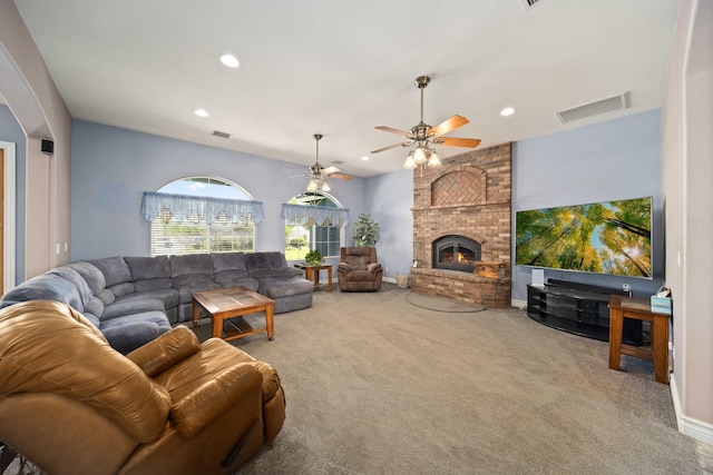 carpeted living room with a fireplace and ceiling fan