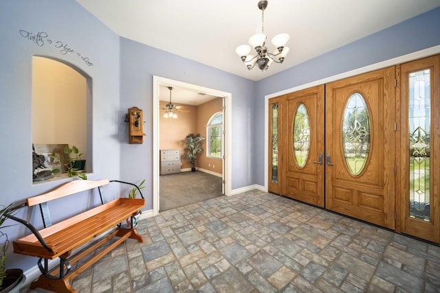 entryway with french doors and ceiling fan with notable chandelier