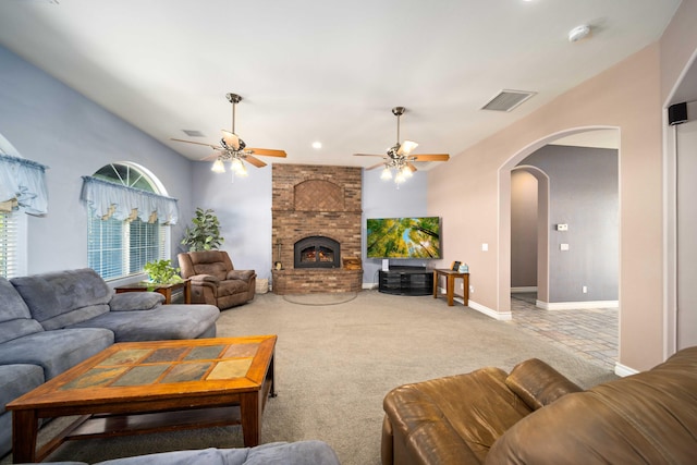 living room featuring carpet, ceiling fan, and a brick fireplace