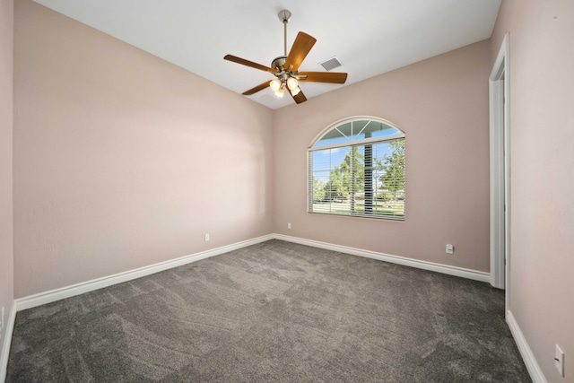 spare room featuring dark colored carpet