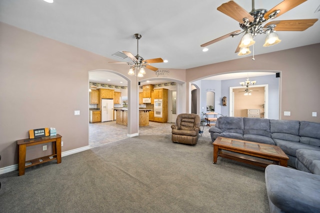 carpeted living room featuring ceiling fan with notable chandelier