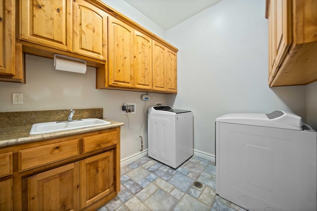 laundry area featuring cabinets, washer and clothes dryer, and sink