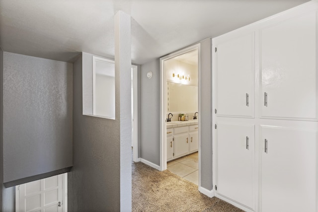 corridor with light carpet and sink