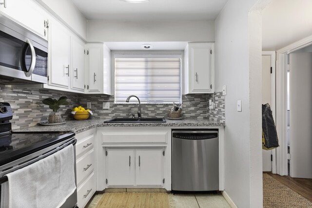 kitchen featuring white cabinets, decorative backsplash, sink, and stainless steel appliances