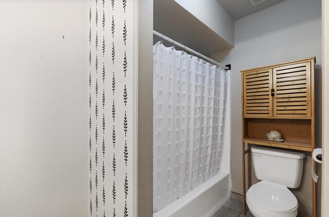 bathroom with tile patterned flooring, toilet, and shower / tub combo