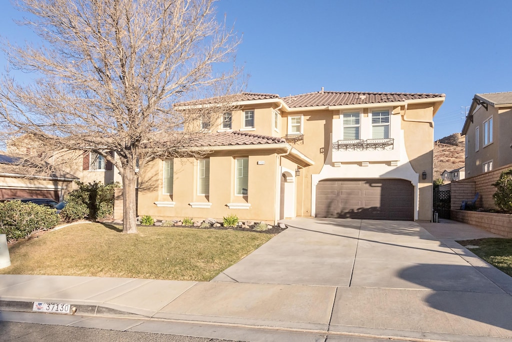 mediterranean / spanish house with a front yard and a garage