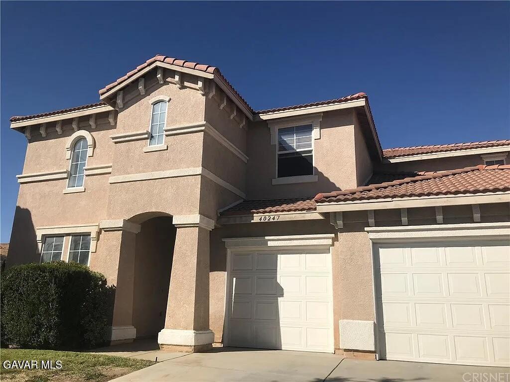 40247 Preston Rd, Palmdale, CA 93551 - mediterranean / spanish-style home with driveway, stucco siding, a tiled roof, and a garage
