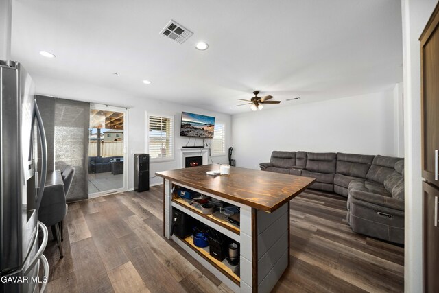2038 Howard St, Rosamond, CA 93560 - kitchen with stainless steel refrigerator with ice dispenser, dark wood-type flooring, ceiling fan, a warm lit fireplace, and recessed lighting