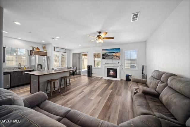 2038 Howard St, Rosamond, CA 93560 - living area featuring light wood-style flooring, a ceiling fan, recessed lighting, and a glass covered fireplace