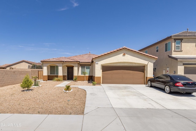 2038 Howard St, Rosamond, CA 93560 - mediterranean / spanish-style home featuring stucco siding, concrete driveway, a tiled roof, and an attached garage