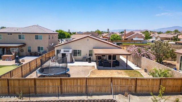 2038 Howard St, Rosamond, CA 93560 - back of property with a patio, a trampoline, a fenced backyard, and a residential view