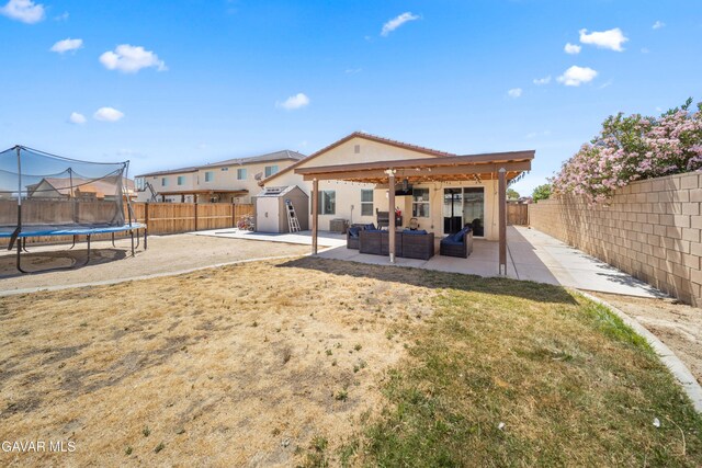 2038 Howard St, Rosamond, CA 93560 - rear view of house with a storage shed, a trampoline, a patio, outdoor lounge area, and a fenced backyard