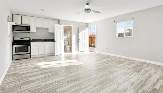 209 Pictorial St, Palmdale, CA 93550 - kitchen featuring stainless steel appliances, a ceiling fan, baseboards, and light wood-type flooring