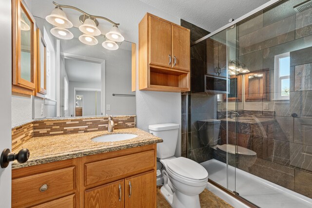 bathroom featuring vanity, a stall shower, toilet, and visible vents
