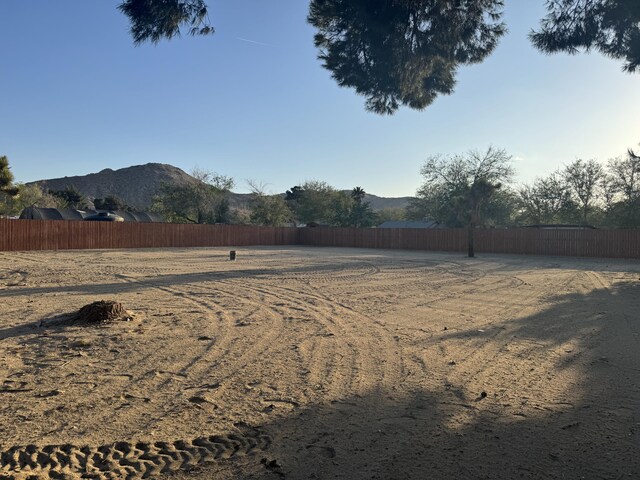 view of yard featuring fence and a mountain view