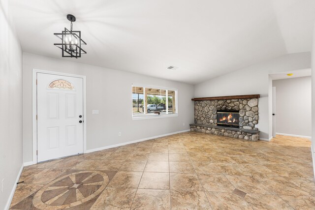 foyer entrance featuring visible vents, baseboards, a fireplace, and an inviting chandelier