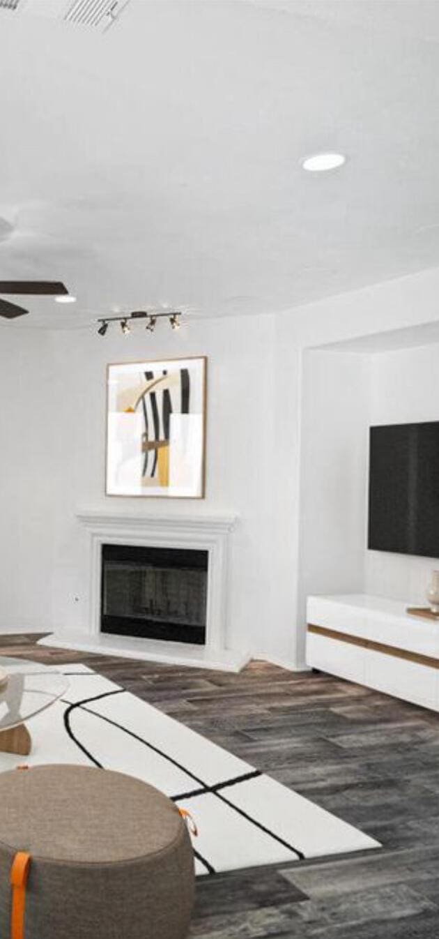 unfurnished living room featuring a glass covered fireplace, visible vents, and wood finished floors